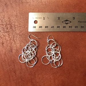 Silver tone pierced earrings.